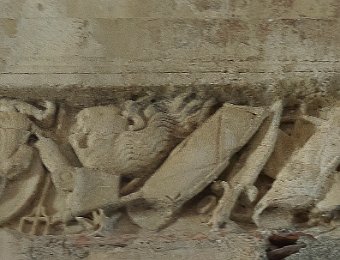 Sculpture romaine représentant à l'envers un captif barbare et un bouclier décoré d'une face de Gorgone entouré de trophées, de casques et d'armes.