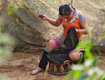Femme H'mong brodant un châle traditionnel